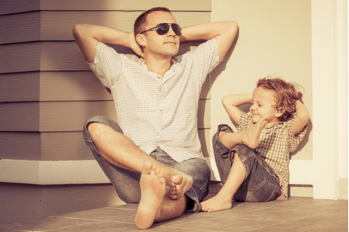 father and son on porch with hands behind head