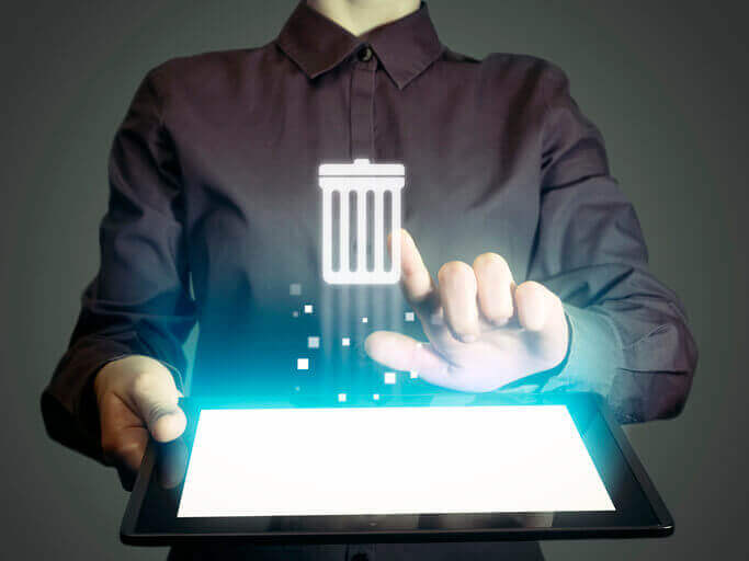 a man holding a tablet with a trash can on it.