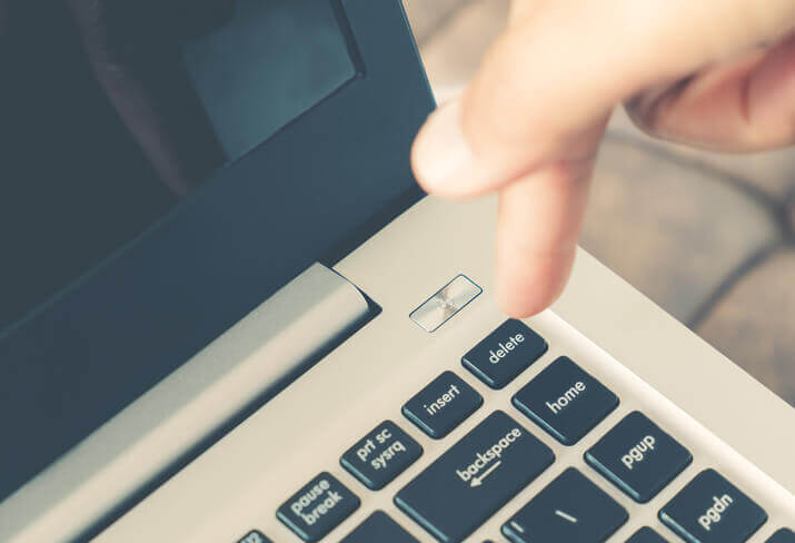 a close up of a person typing on a laptop.