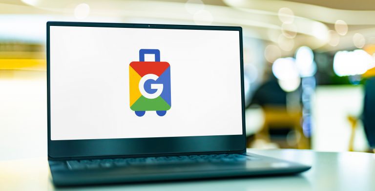 A laptop with the google logo on it is sitting on a table, providing travel site data protection.